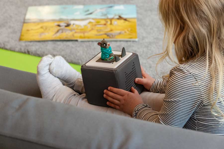 Ein Kind mit einem Spielzeug auf einer Couch