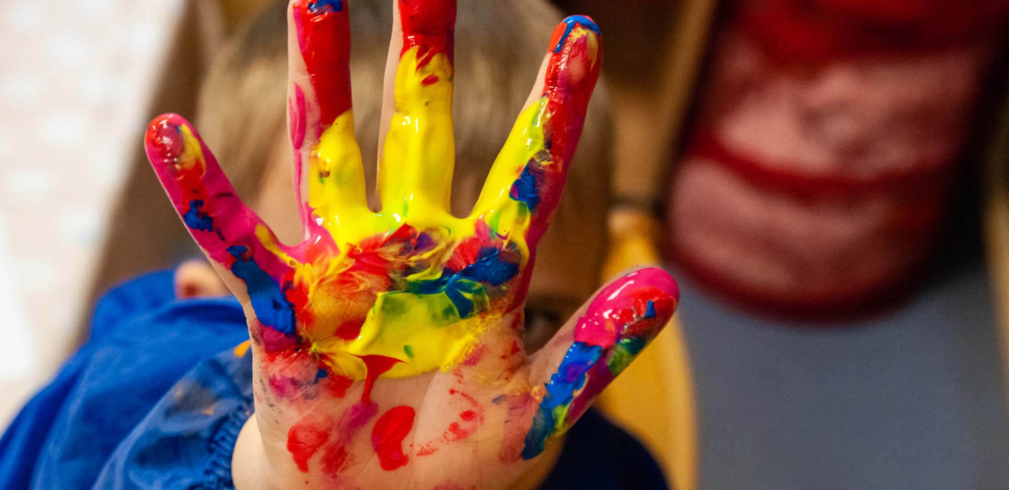 Ein Kind hält eine bemalte Hand in die Kamera